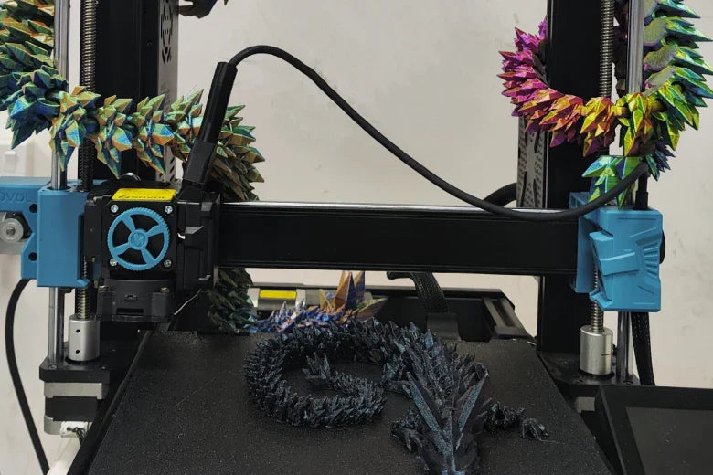 3D printer creating articulated dragon model with colorful filament and spiked texture