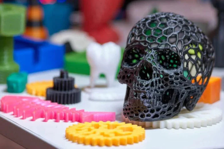 3D printed skull model with honeycomb pattern and colorful plastic gears on a table