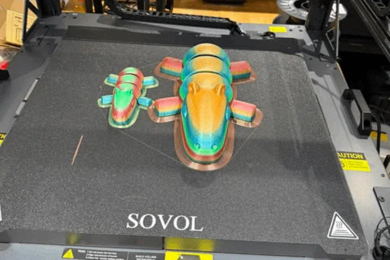 3D printer bed with two colorful 3D printed animals and SOVOL branding
